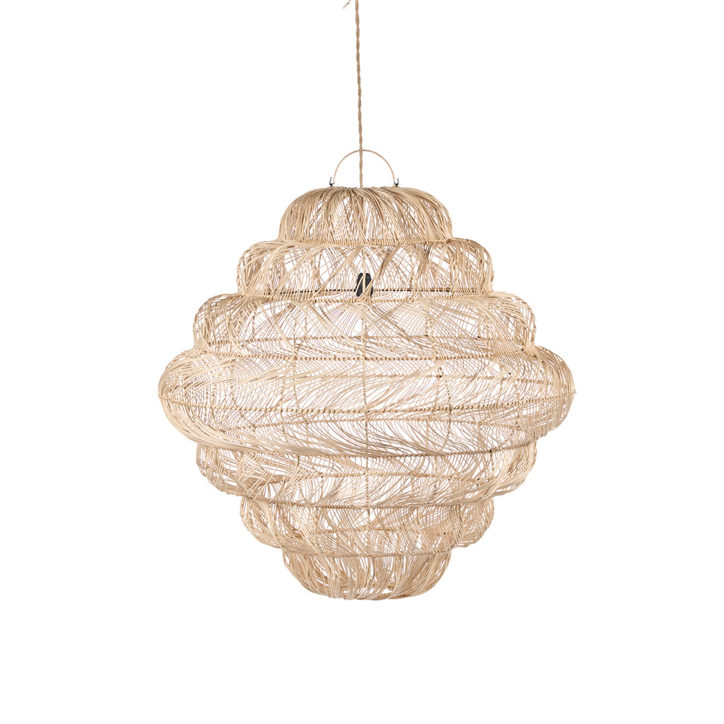 A large, tiered wicker pendant chandelier hangs in a bright, sunlit outdoor patio lounge area with a white sofa, wooden coffee table, and potted plants.