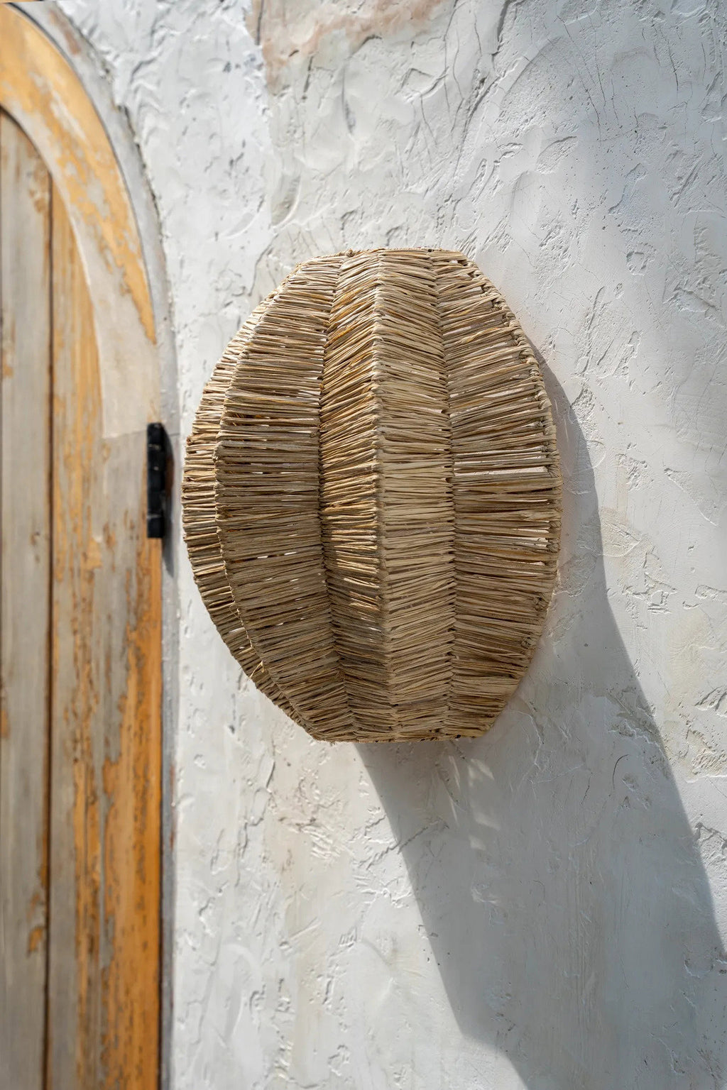 Woven rattan wall applique on a white background