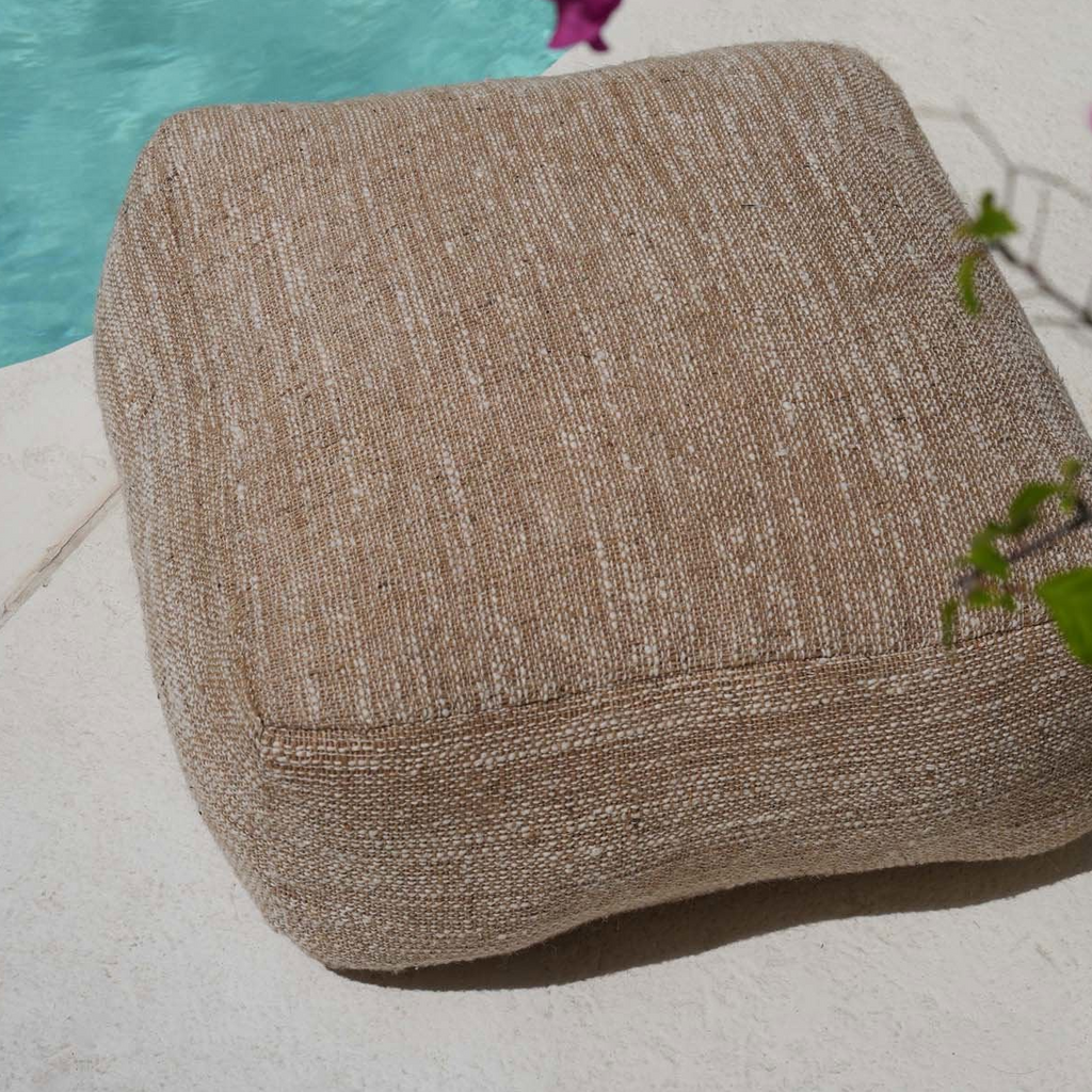 Beige textured pouffe on a white background