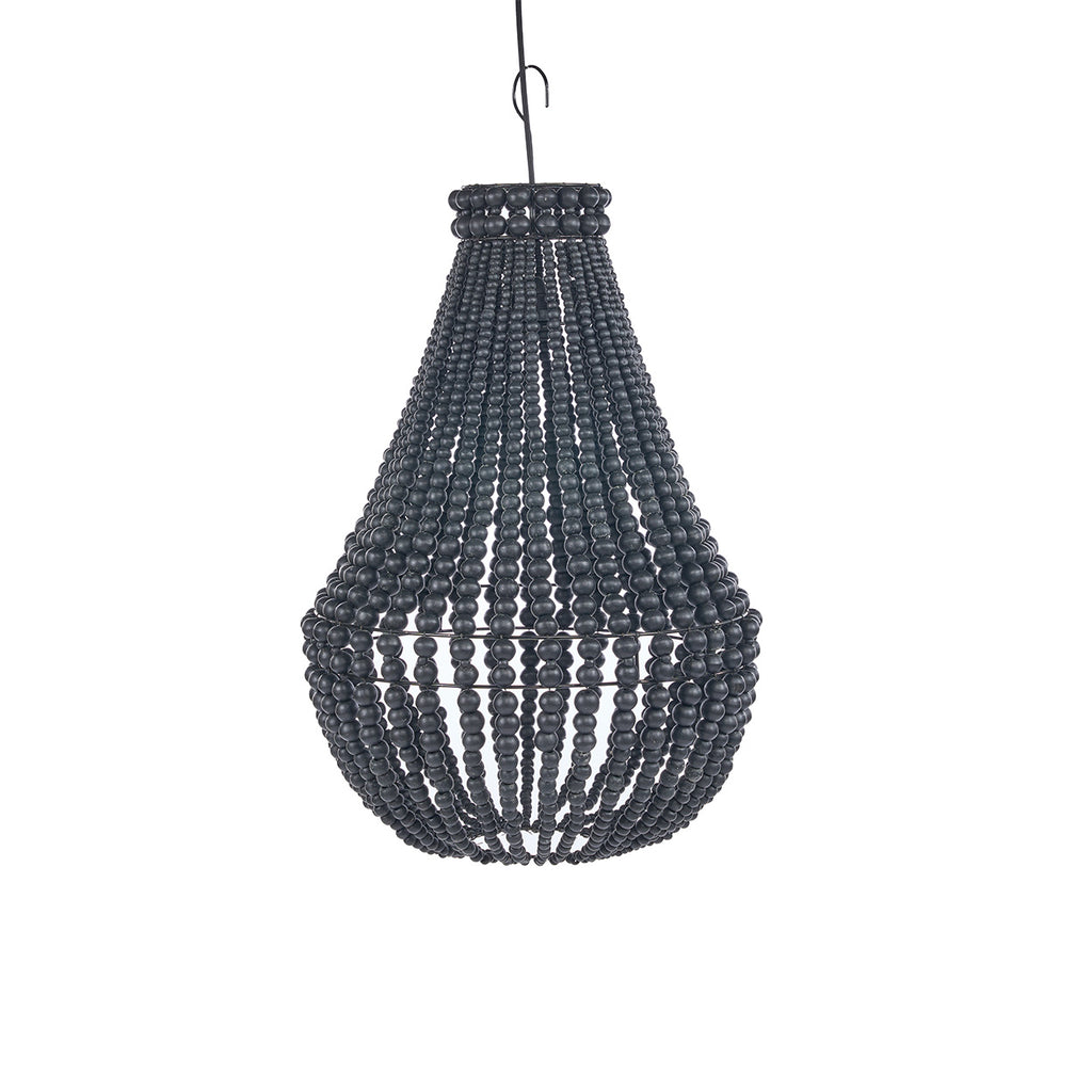 A dark woven beaded chandelier hangs over a rustic outdoor patio seating area at dusk, with a sofa, table, plants, and warm ambient lighting in the background.